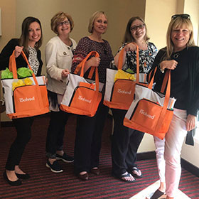 Employees holding swag bags